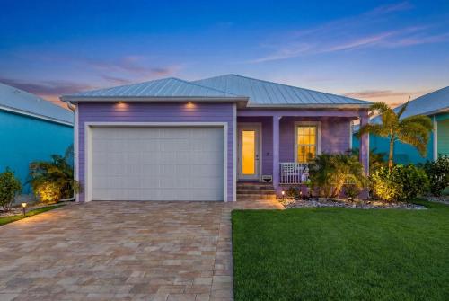 a purple house with a garage in a yard at Lavender Life in Saint James City