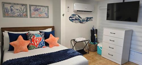 a bedroom with a bed with pillows and a flat screen tv at Los Roires Beach Apartments in Fajardo