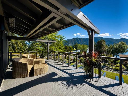 a deck with a view of the mountains at Designer Lakefront Condo E3 Wapato Point Chelan in Manson
