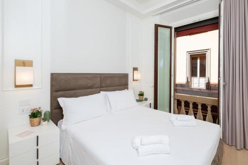 a bedroom with a large white bed and a window at Mamma Mia Holidays - Dimore Maggiori in Bologna