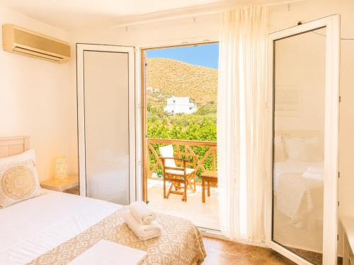 a bedroom with a bed and a balcony at Villa Sofia in Agios Petros