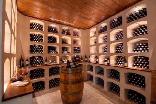 a wine cellar with a barrel and a wall of wine bottles at Chianti Escape PoolVines Tenuta Bibbiano-I Sodi in Castellina in Chianti