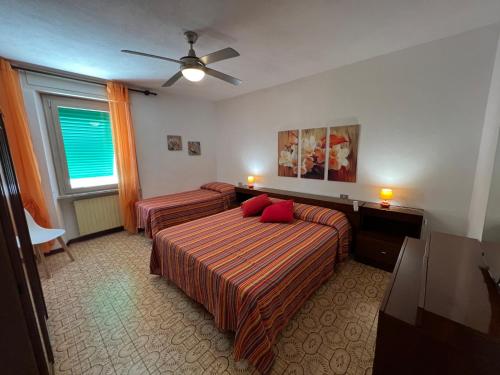 a hotel room with two beds and a ceiling fan at Appartamenti Via Roma 41 in Campo nell'Elba