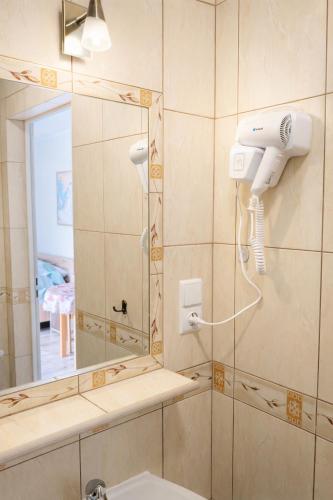 a bathroom with a blow dryer and a mirror at Róża Wiatrów in Rowy