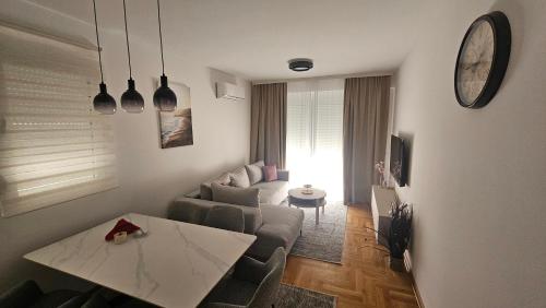 a living room with a couch and a table at Apartman E&A in Radanovići