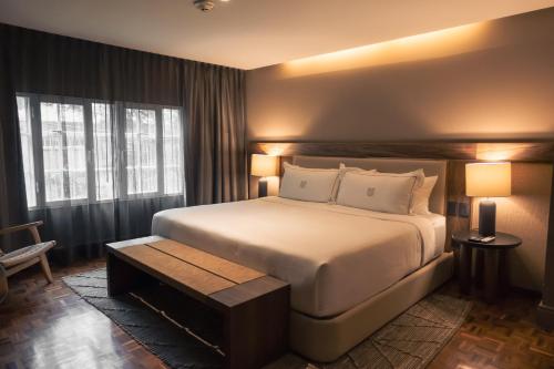 a bedroom with a large white bed and a table at Maria Condesa Boutique in Mexico City