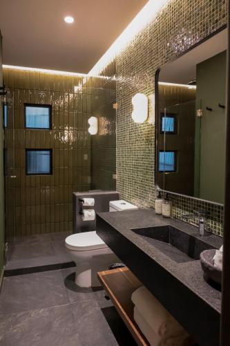 a bathroom with a toilet and a sink and a mirror at Maria Condesa Boutique in Mexico City