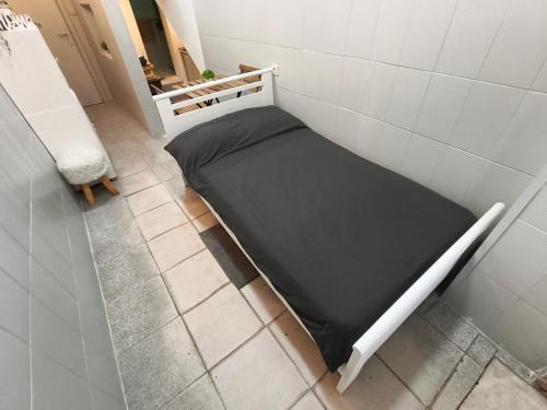 a small bed in a corner of a room at Estúdio Madragoa in Lisbon
