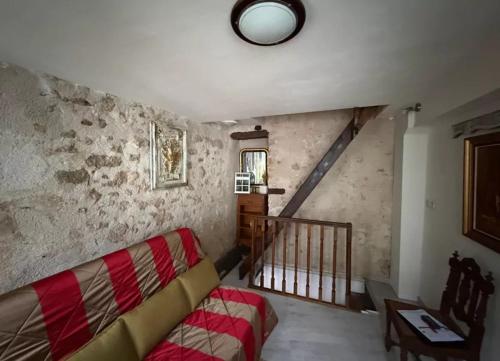 a living room with a couch and a staircase at Maison atypique et confortable in Mamers