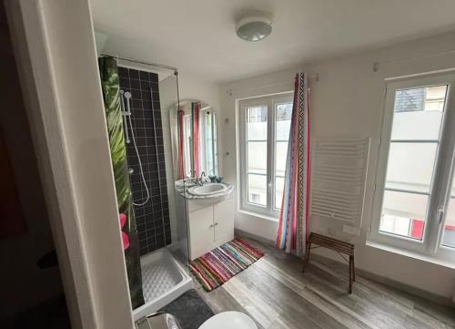 a bathroom with a sink and a shower in it at Maison atypique et confortable in Mamers