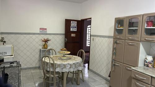 a kitchen with a table and chairs and a refrigerator at Pousada e Hostel Rodo in São Carlos