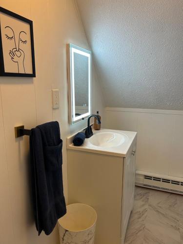 a white bathroom with a sink and a window at The Emerald Cabin in Tobyhanna