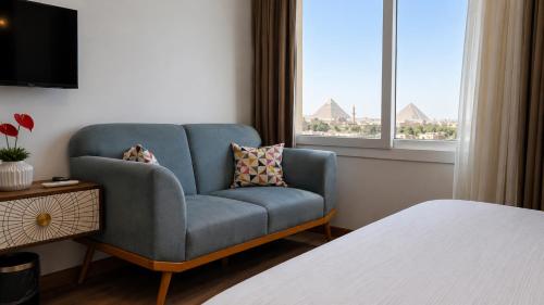 a living room with a blue chair and a window at La Veranda Pyramids View Hotel in Cairo