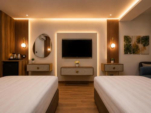 a hotel room with two beds and a flat screen tv at La Veranda Pyramids View Hotel in Cairo