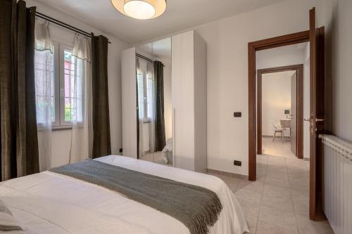 a white bedroom with a bed and a bathroom at Casa Le Camelie idromassaggio e relax Lucca in Capannori