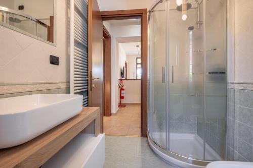 a bathroom with a sink and a glass shower at Casa Le Camelie idromassaggio e relax Lucca in Capannori