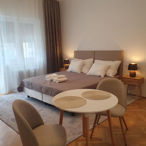 a bedroom with a bed with a table and chairs at Bzs5 in Pécs