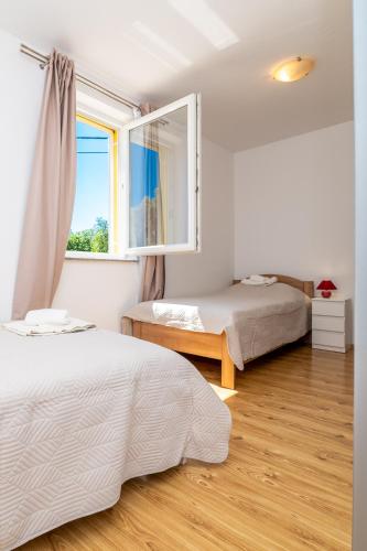 a bedroom with two beds and a window at Casa delle Rondini in Belej