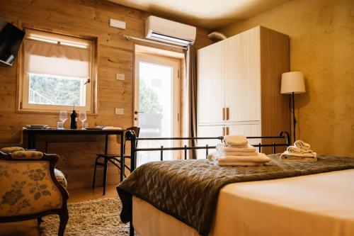 a bedroom with a bed and a desk and a window at La Contrà Valpolicella in Fumane