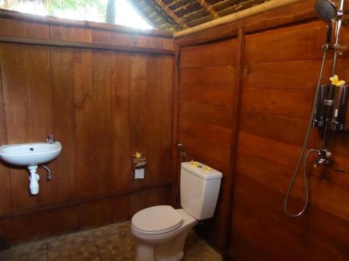 a bathroom with a toilet and a sink at Shibui Garden Bungalows and Restaurant in Tanjung