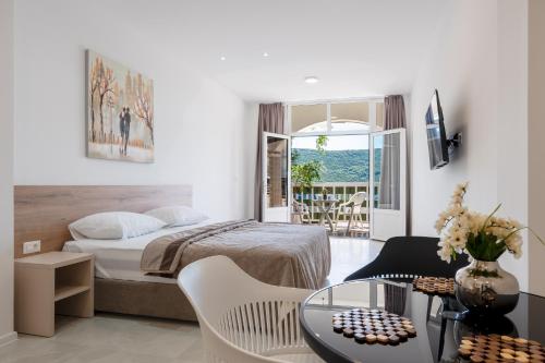 a hotel room with a bed and a table and chairs at Apartments Obradović in Neum