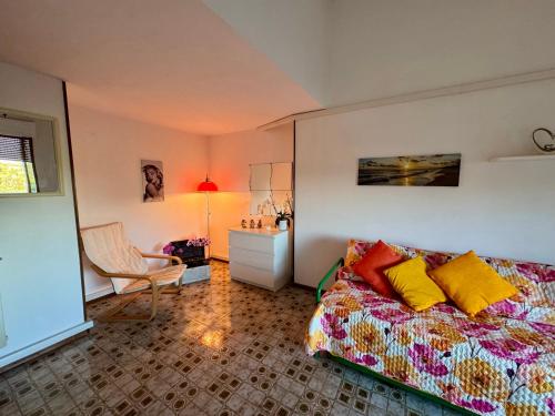 a bedroom with a bed and a chair at Luna e Sentidu in Villaputzu