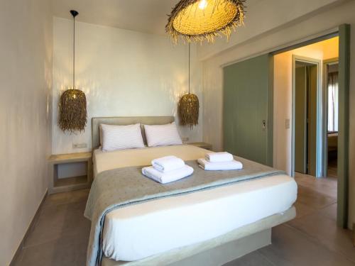 a bedroom with a bed with two towels on it at Mikres Cyclades - Koufonisia House in Koufonisia