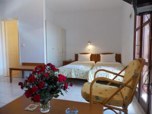 um quarto com duas camas e uma mesa com um vaso de flores em Kato Zakros Palace Apartments em Káto Zákros