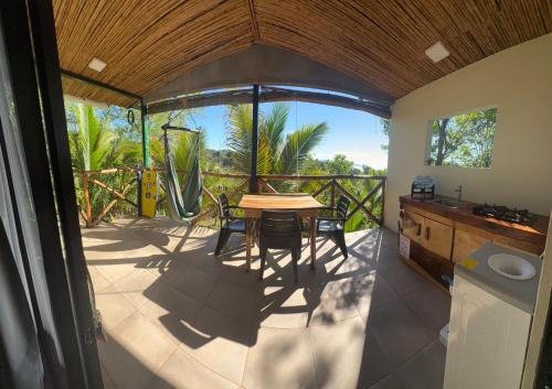 a kitchen with a table and chairs on a balcony at Surf Lodge El Carrizal-Punta Mango in La Periquera