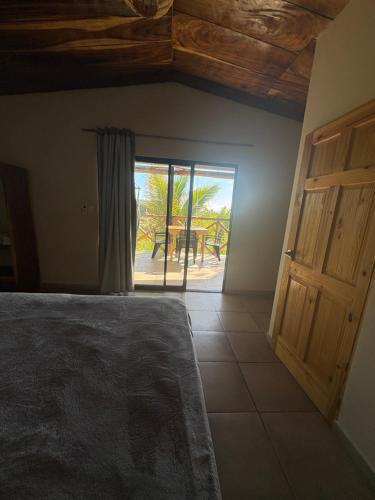 a bedroom with a bed and a door to a patio at Surf Lodge El Carrizal-Punta Mango in La Periquera
