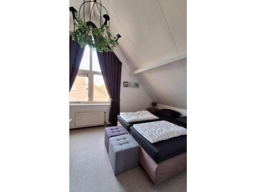 a room with a bed and a couch and a window at Bungalow in Breskens near Beach & Lighthouse in Breskens