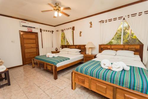 a bedroom with two beds with white towels on them at Falling Leaves Lodge in San Ignacio