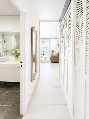 a hallway with white walls and a mirror and a bathroom at Studio ALIZEA in Saint Martin