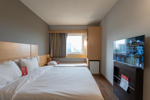 a hotel room with a bed and a television at ibis Sorocaba in Sorocaba