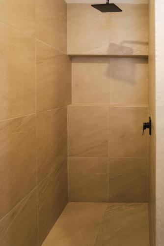 a walk in shower with a large tile wall at Hotel Hacienda Concá in Conca