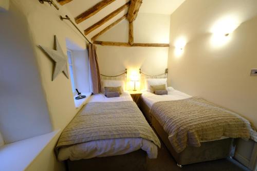 two beds in a room with a star on the wall at Rose Cottage in Buxton