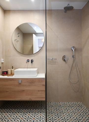 a bathroom with a shower with a sink and a mirror at Mandrakia Living House in Mandrakia