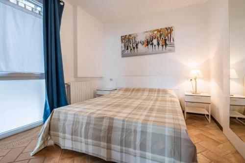 a bedroom with a bed with a plaid blanket at Al Agave sotto in Toscolano Maderno