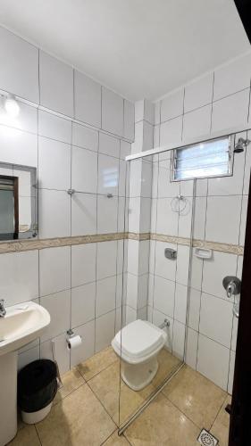 a bathroom with a toilet and a sink at Hostel Peter Pan in Puerto Iguazú