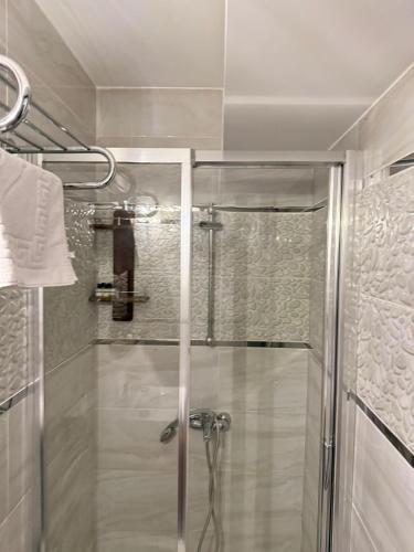 a shower with a glass door in a bathroom at Ceren pansiyon in Seferihisar