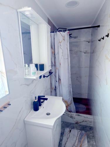 a white bathroom with a toilet and a sink at Peđa in Ogulin