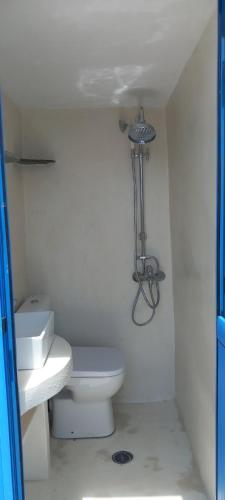 a white bathroom with a toilet and a sink at John's View in Serifos Chora