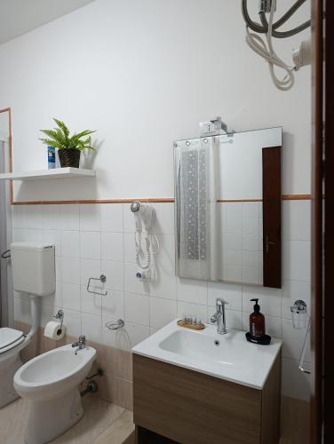 a bathroom with a sink and a toilet and a mirror at Casa Melf in Terrasini