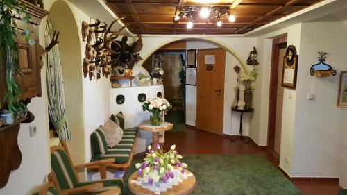 a living room with chairs and a table with flowers at Hotel Ehrenreich in Sankt Anton am Arlberg