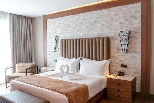 a bedroom with a large bed and a brick wall at Hotel Ronda Minerva in Guadalajara