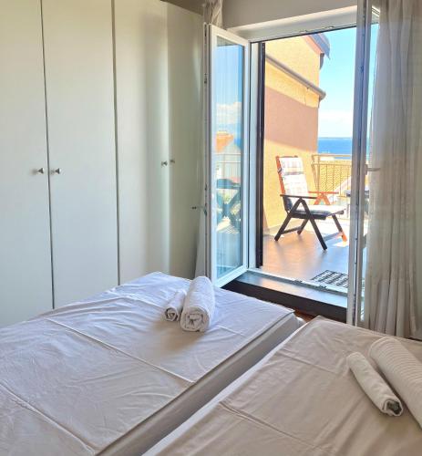a bedroom with a bed and a view of a balcony at Falcon in Mali Lošinj