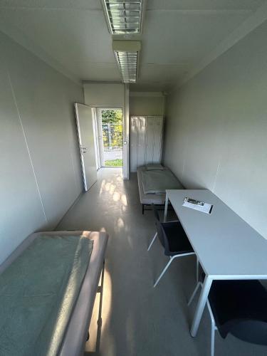 a room with beds and a desk and a table at Tinyhome Spielberg -Glamping Container in Flatschach