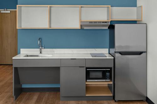 a kitchen with a sink and a microwave at StudioRes by Marriott Greensboro Airport in Greensboro