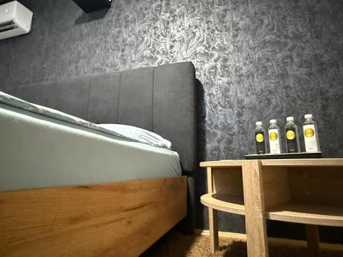 a bedroom with three bottles of wine on a table at Apartmani Benjamin in Tuzla