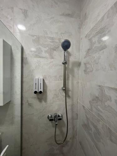 a shower with a shower head in a bathroom at Zen Central Gevgelija in Gevgelija